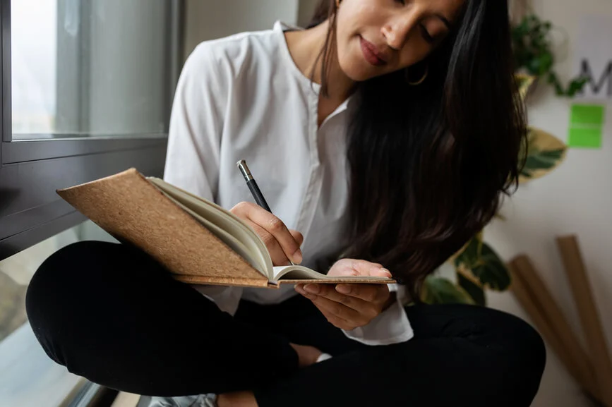 woman writing in journal how to start journaling